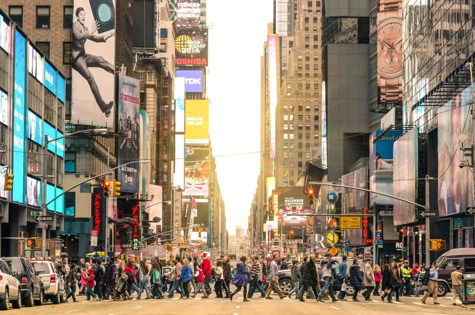 crowd of people walking across the street New York City scaled.jpg