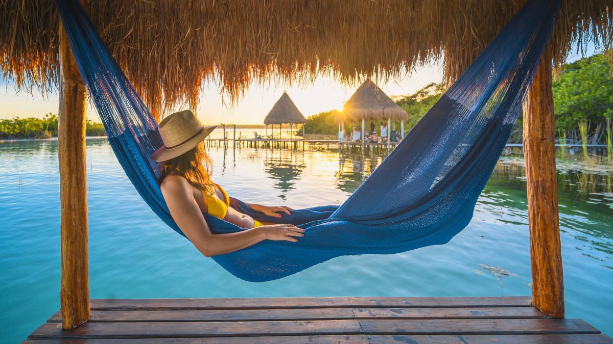Woman relaxing on a hammock under a palapa