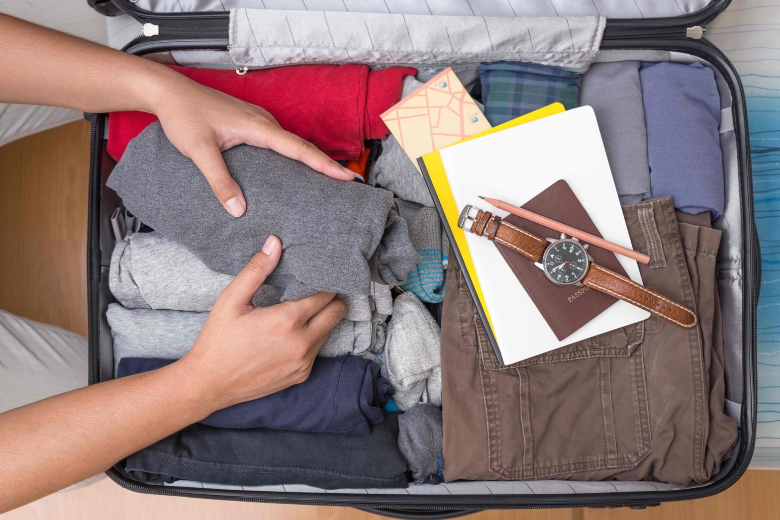 Man packing basic clothing into suitcase scaled.jpg