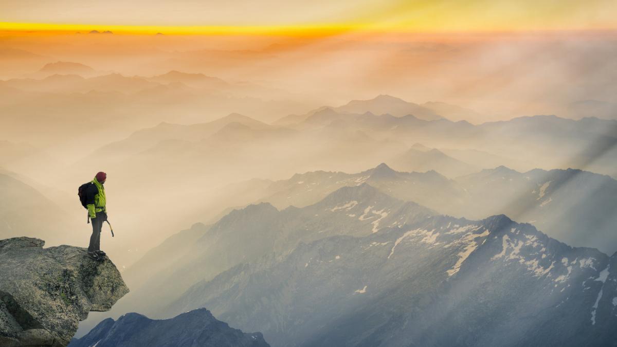 Mountain climber standing on edge of mountain looking at view C.jpg