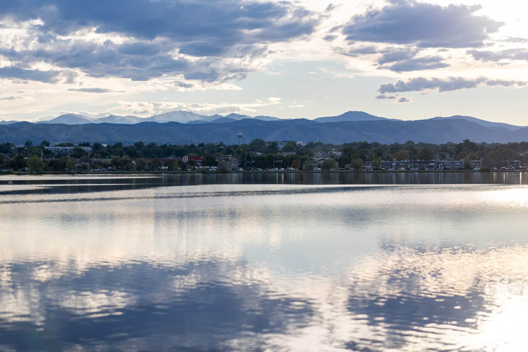 Best things to do in Denver – city life, nature & experiences - Denver’s Sloan Lake with houses in the middle and the Rocky Mountains in the background