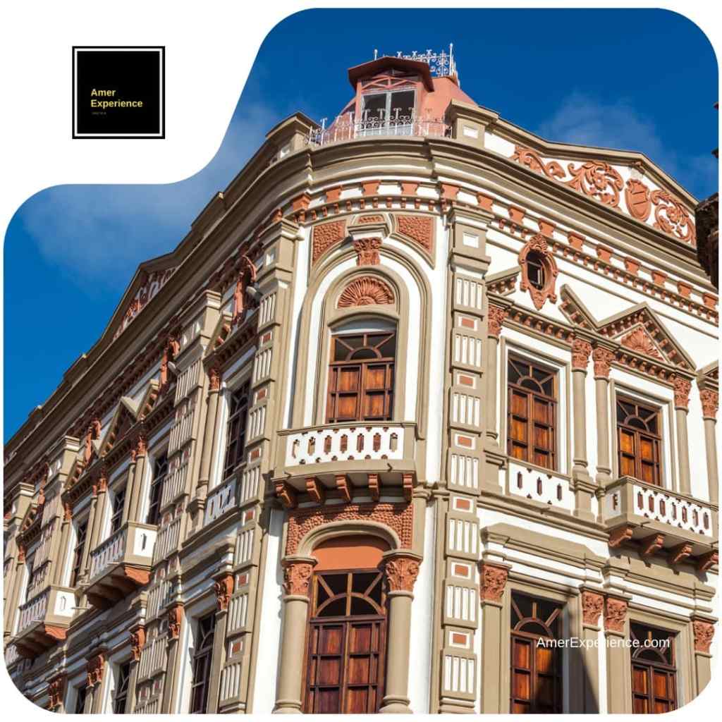 Ornate cream and terracotta façade with wooden windows and balconies in Cuenca’s historic centre.